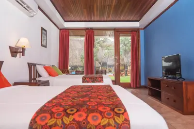 a hotel room with two beds and a television at Nandel Beach Resort in La Cruz