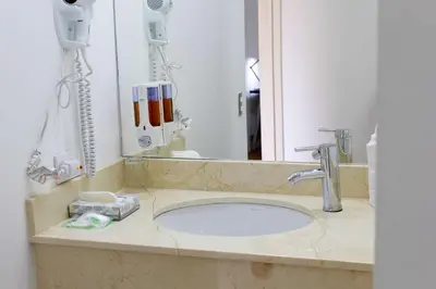 a bathroom counter with a sink and a mirror at Hotel Zima in San Isidro