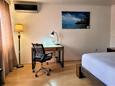 a bedroom with a bed and a desk and a chair at Hotel Zima in San Isidro