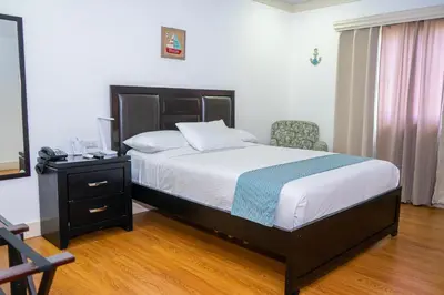 a bedroom with a bed and a desk and a chair at Hotel Zima in San Isidro