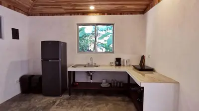 a kitchen with a sink and a refrigerator at Armadillo Bungalows, walk to the Beach - Santa Teresa in Santa Teresa Beach