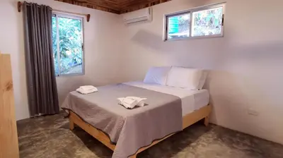 a bedroom with a bed with two towels on it at Armadillo Bungalows, walk to the Beach - Santa Teresa in Santa Teresa Beach