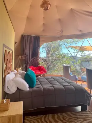 a bedroom with a bed with pillows and a window at Kintiri Glamping in Nicoya