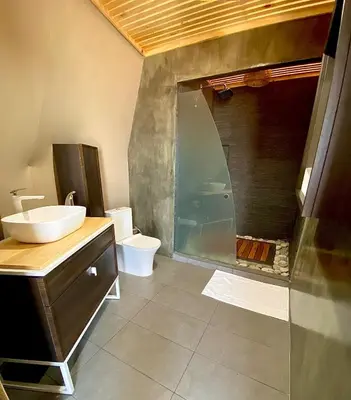 a bathroom with a shower and a sink and a toilet at Kintiri Glamping in Nicoya