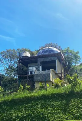 a house on top of a hill with grass at Kintiri Glamping in Nicoya
