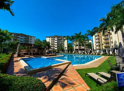 a swimming pool in a resort with palm trees and buildings at Costa Linda 6-08 in Jacó