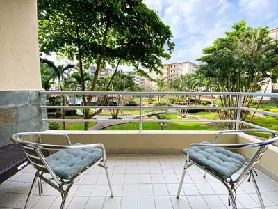 two chairs on a balcony with a view of a park at Costa Linda 6-08 in Jacó