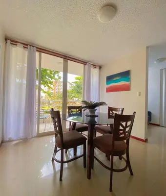 a dining room with a table and chairs and a window at Costa Linda 6-08 in Jacó