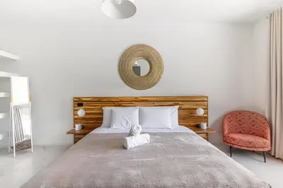 a bedroom with a large bed and a chair at Peace Villa Santa Teresa - Walking distance to the beach in Santa Teresa Beach