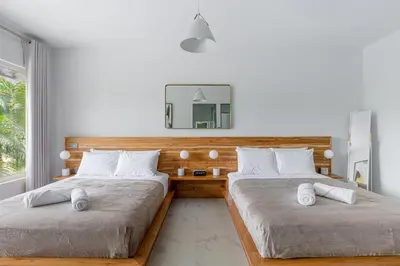 a bedroom with two beds and a mirror on the wall at Peace Villa Santa Teresa - Walking distance to the beach in Santa Teresa Beach