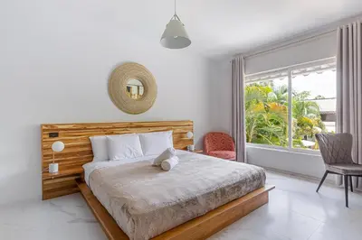 a bedroom with a bed and a large window at Peace Villa Santa Teresa - Walking distance to the beach in Santa Teresa Beach