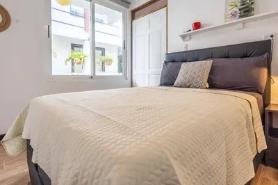 a bedroom with a large bed with a window at BUDDA HOME in Tortuguero