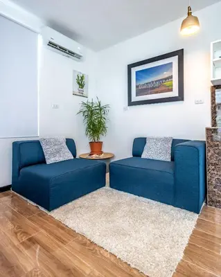 a living room with two blue couches at BUDDA HOME in Tortuguero