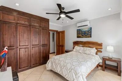 a bedroom with a bed and a ceiling fan at Elegant Oceanview Condo with Spacious Open-Concept Floor Plan and Inviting Beach Design in Playa Flamingo