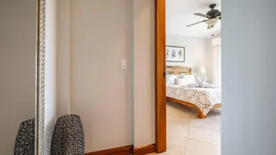 a mirror in a bedroom with a bed and a ceiling fan at Elegant Oceanview Condo with Spacious Open-Concept Floor Plan and Inviting Beach Design in Playa Flamingo