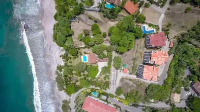 an aerial view of a house on the beach at Elegant Oceanview Condo with Spacious Open-Concept Floor Plan and Inviting Beach Design in Playa Flamingo