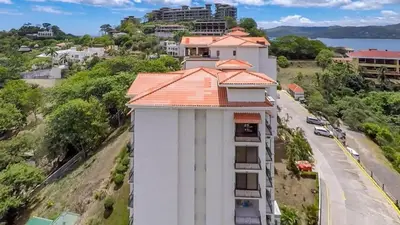 an aerial view of a building with an orange roof at Elegant Oceanview Condo with Spacious Open-Concept Floor Plan and Inviting Beach Design in Playa Flamingo