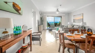a dining room and living room with a table and chairs at Elegant Oceanview Condo with Spacious Open-Concept Floor Plan and Inviting Beach Design in Playa Flamingo