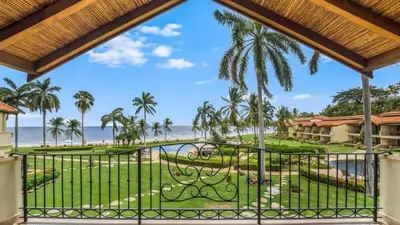 a view of the beach from the balcony of a resort at Chic Condo with a Stylish Coastal Design in an Exclusive Condo Community with Direct Beach Access in Playa Flamingo
