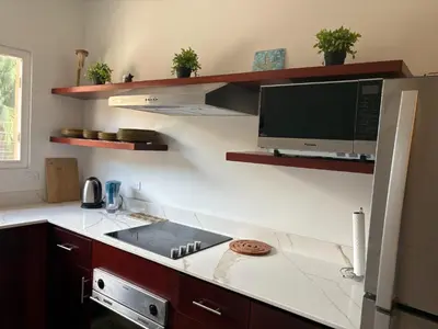 a kitchen with a counter top with a tv on the wall at Jazmin Del Sol steps away from Playa Potrero !! in Potrero