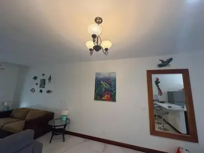 a living room with a couch and a mirror at Jazmin Del Sol steps away from Playa Potrero !! in Potrero
