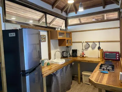 a kitchen with a stainless steel refrigerator and a counter at Ginger Studio in Santa Teresa Beach