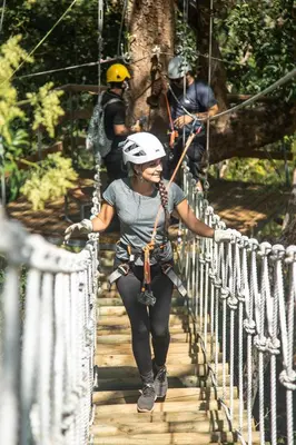 a woman crossing a rope bridge on a zip line at Spacious 4BR Condo with Partial Ocean View - Bougainvillea - Reserva Conchal in Playa Conchal