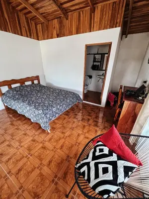 a room with a bed and a mirror at El Nido Lodge in Monteverde Costa Rica
