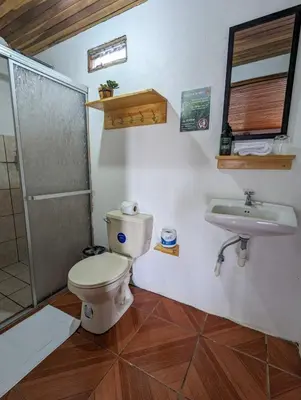 a bathroom with a toilet and a sink at El Nido Lodge in Monteverde Costa Rica