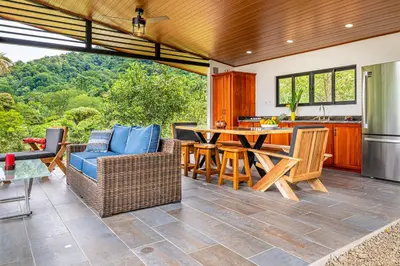 an open kitchen and living room with a table and chairs at The Sutton - Boutique Jungle Experience - Walk to Envision Festival in Uvita