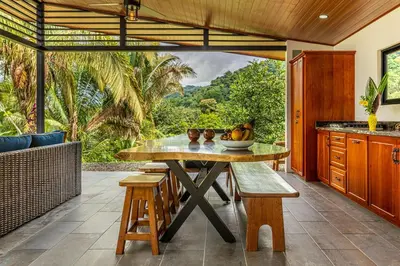 a kitchen with a table with a bowl of fruit on it at The Sutton - Boutique Jungle Experience - Walk to Envision Festival in Uvita