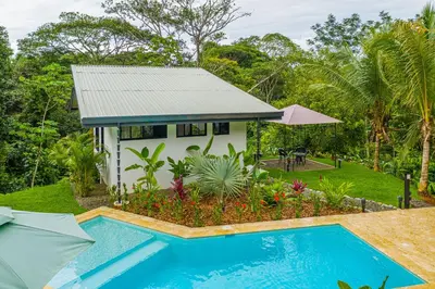 a villa with a swimming pool and a house at The Sutton - Boutique Jungle Experience - Walk to Envision Festival in Uvita