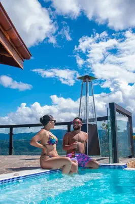a man and a woman sitting in a swimming pool at Hotel Pico Colorado in Aserrí