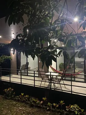 a table and chairs on a deck at night at Bongalow Villa Sarchi in Sarchí