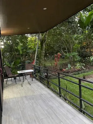 a patio with a table and a bench on a fence at Bongalow Villa Sarchi in Sarchí