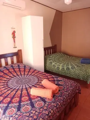 a bedroom with two beds and an umbrella on the bed at Nasu Lodge in La Cruz