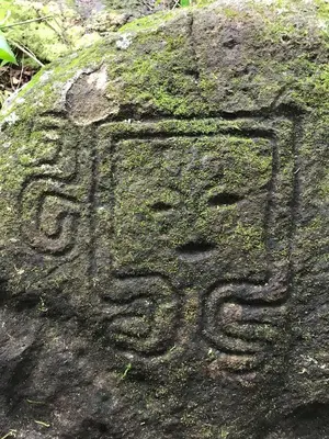 a rock with a carving of a person on it at Nasu Lodge in La Cruz
