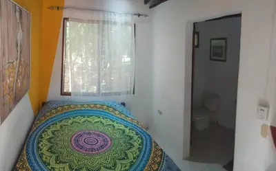 a bedroom with a bed and a window at Nasu Lodge in La Cruz