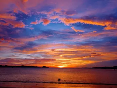 a person standing on the beach at sunset at Nasu Lodge in La Cruz