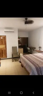 a bedroom with a bed and a chair in it at Hotel la Cueva Limon in Puerto Limón