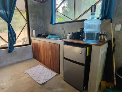a kitchen with a sink and a bottle of water on top at Kinkajoungalows - Amaya Family, Drake Bay, Osa Peninsula in San Pedrillo