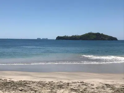 a sandy beach with an island in the ocean at Gray Beach House in Potrero