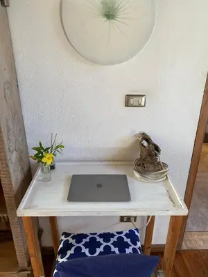 a table with a laptop sitting on top of it at Tropical - Airy, open plan apartment in heart of Santa Teresa in Santa Teresa Beach