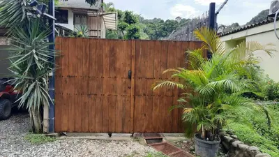 a wooden fence in front of a house at Tropical - Airy, open plan apartment in heart of Santa Teresa in Santa Teresa Beach