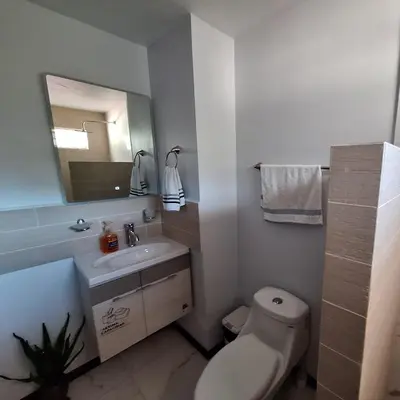 a bathroom with a toilet and a sink and a mirror at Victoria House in San Isidro