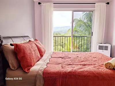 a bedroom with a bed and a large window at Victoria House in San Isidro