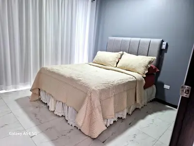 a bed with a blanket and pillows next to a window at Casa Victoria Alojamiento in San Isidro