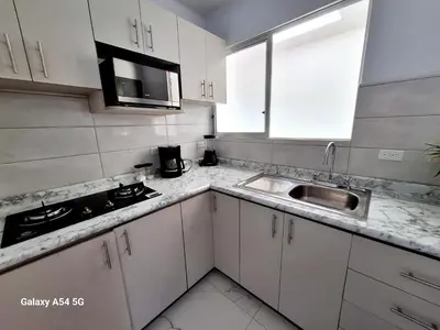a kitchen with white cabinets and a sink at Casa Victoria Alojamiento in San Isidro
