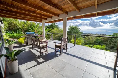 a patio with chairs and a table and a view at Flower’s Paradise Monteverde in Monteverde Costa Rica