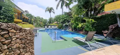 a swimming pool with chairs in a resort at Mangaby Playa Hermosa in Playa Hermosa